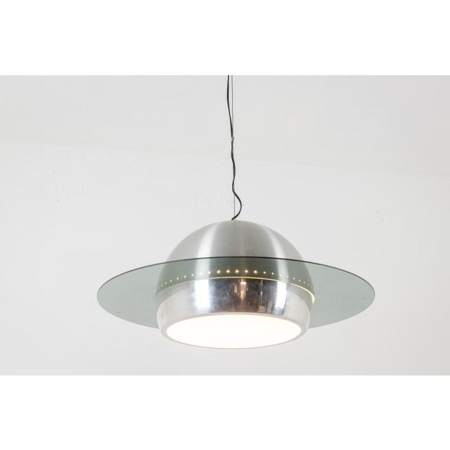 Space Age style pendant light in polished and brushed metal, decorated with a glass ring. Italian work realized circa...