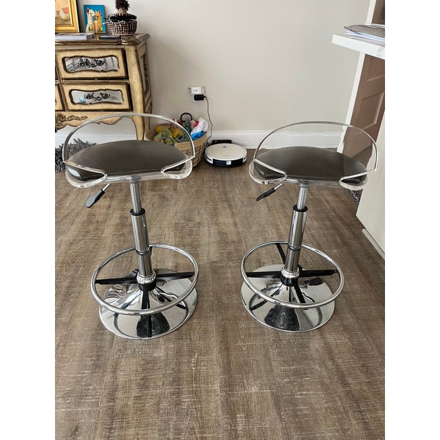 These are 360 degree swivel chairs made in chrome and lucite by the design firm Muniz . Adjustable height from counter to...