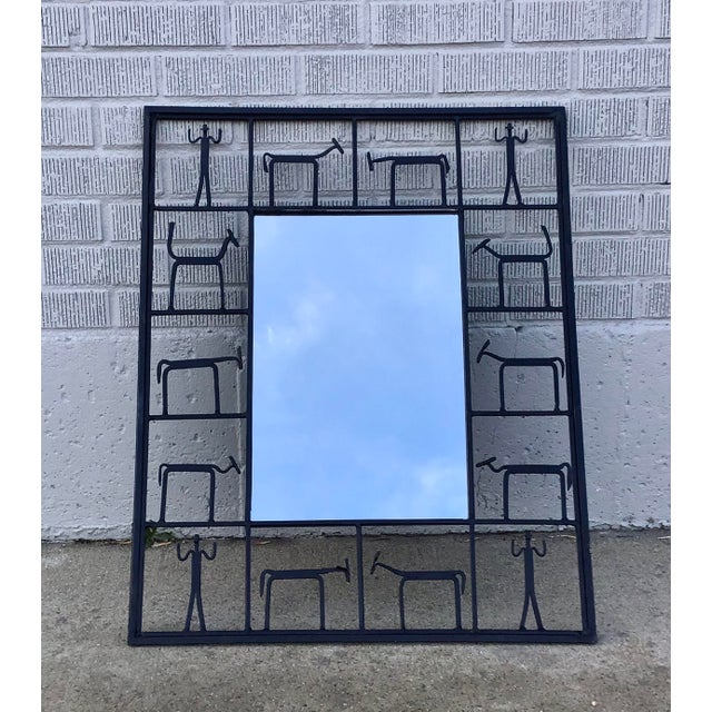 Modernist wall mirror unmarked, but attributed to Frederic Weinberg. The rectangular mirror features a black iron frame...