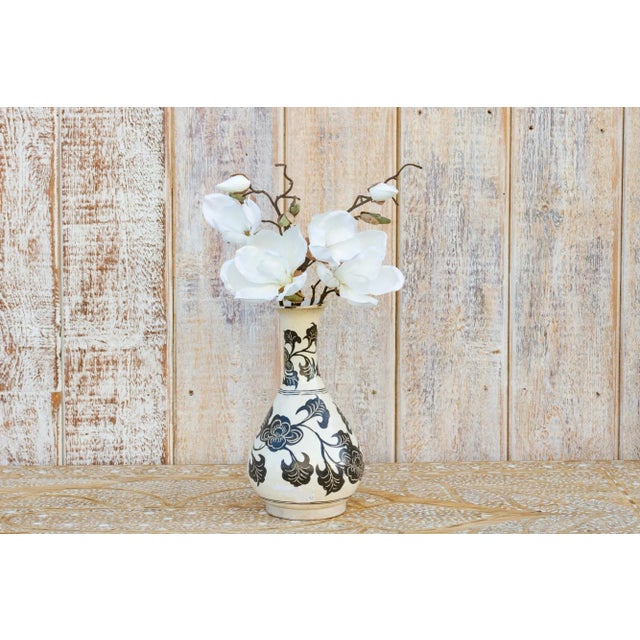 Showing a lovely silhouette, this sophisticated Asian porcelain vase have a black floral and leaf pattern on a creamy...