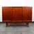 Handsome Rich sculptural Scandinavian Danish modern teak wood Credenza / Highboard. Comes with 3 doors that slide open and...