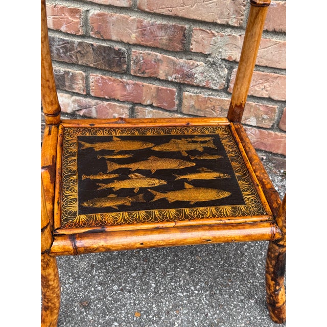 This 19th Century English Bamboo Side table features a delightful variety of fish decoupaged onto the top and lower shelf....