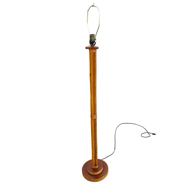 This beautifully restored Rattan pole lamp featuring 3 decorative rattan poles centered around a rattan post all fixed to...