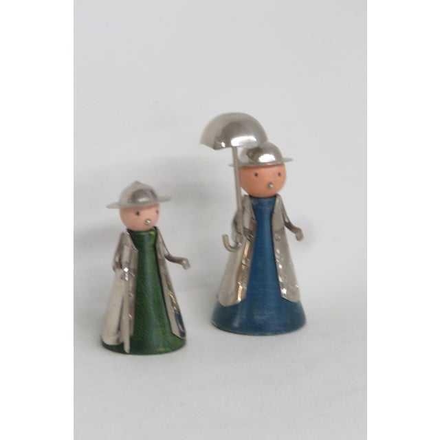 This adorable Figurine Pair of 2 is made out of wood and metal. This lovely pair features a folk art styling of a wooden...