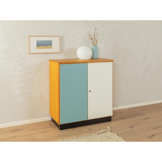 A wonderful chest of drawers from the 1960s. High-quality ash veneer body with two Formica-covered cabinet doors in dove...