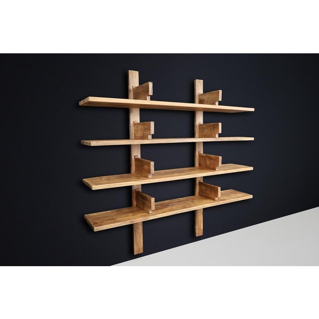 Patinated Elm Bookshelf in the Style of Pierre Chapo, France 1970s A striking and robust wall-mounted bookshelf crafted in...