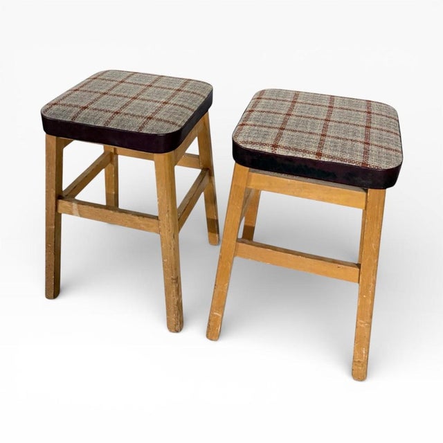 This pair of mid century stools offers vintage oak stools crafted with solid oak frames and original tweed upholstered...