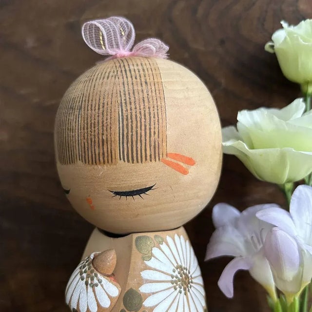 This adorable kokeshi, 'Hinagiku' style, is created by the renowned artist Aoki Ryoka. This particular piece, named 'Daisy...