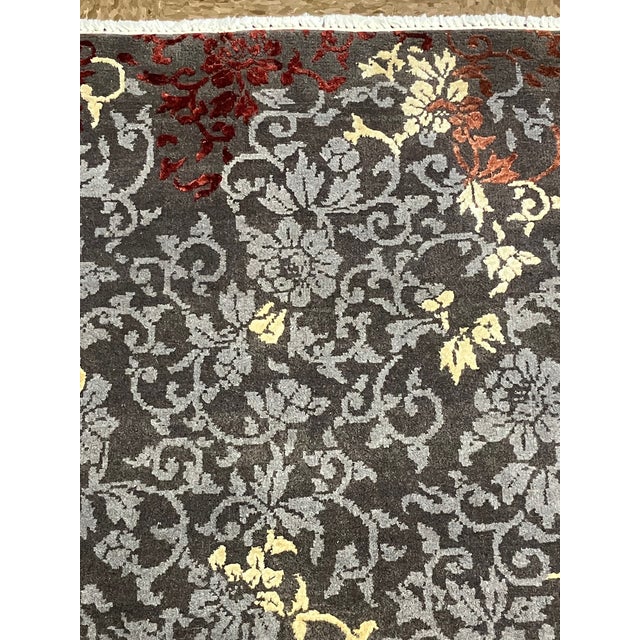 Hand-knotted Indian rug with an allover floral vine pattern set against a charcoal field. Features scrolling botanical...