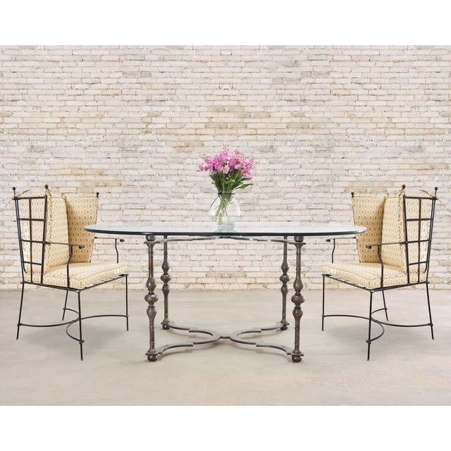 A substantial wrought iron and oval glass-top dining or center table crafted in a stately Baroque style by California...