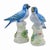 A pair of vintage Chelsea House bird figures with blue-and-white plumage, long tails, and pale leafy bases accented with...