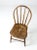 This is an antique bow back Winsdor chair. The classic farmhouse dining chair has splayed wood legs and a spindle bowed back.