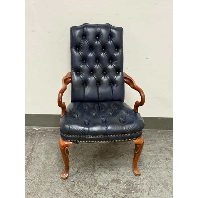 Design Plus Gallery presents a Vintage Traditional Queen Anne Style Tufted Blue Leather Armchair. The chair has a tall...
