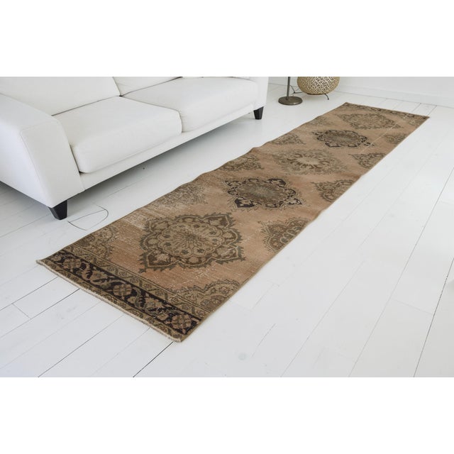 This is a vintage Turkish Oushak rug from the Mid 20th Century. The piece was hand-knotted.