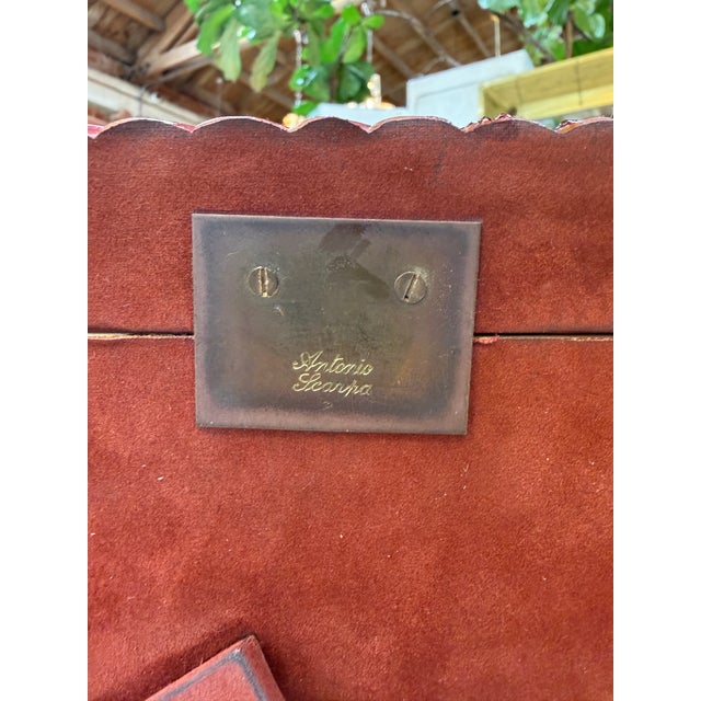 Decorative tabletop picture frame featuring a deep burgundy finish and a sculptural border with flowing, twisted ridges....