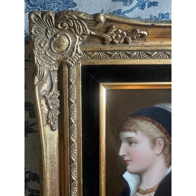 A finely hand-painted antique porcelain portrait plaque depicting an elegant young woman in profile, dressed in...