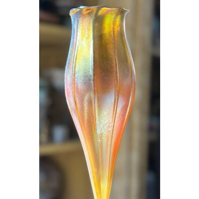 A colorful iridescent favrile glass vase in beautiful tulip form by Louis Comfort Tiffany. Signed on the base. This LC...