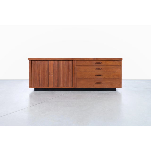 Mid-century walnut tambour door credenza designed by Milo Baughman and manufactured by Glenn of California in the United...