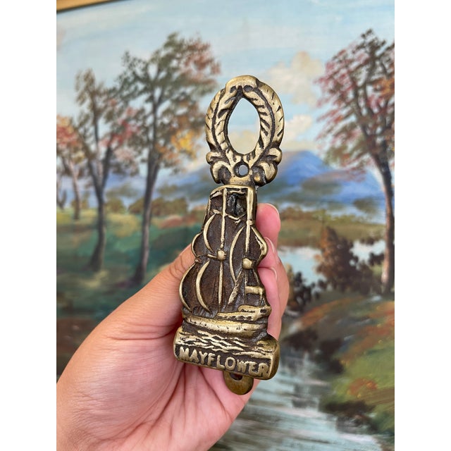 A door knocker depicting the historic Mayflower ship in full sail, with the word "MAYFLOWER" inscribed at the base. The...