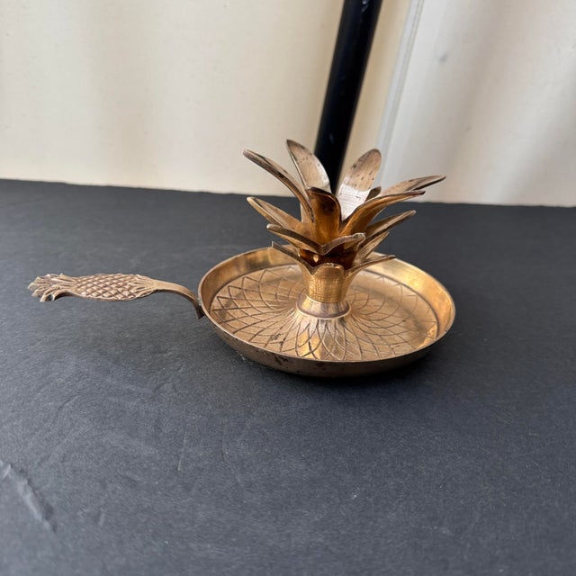 Vintage brass pineapple candlestick holder with a pineapple handle. Has been polished and lacquered so it will retain its...