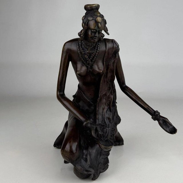 A striking and evocative 19th-century European bronze sculpture depicting an African mother carrying her young child upon...