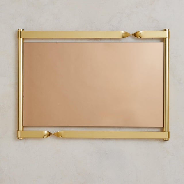 A sculptural Italian wall mirror by Luciano Frigerio, 1970s. The polished brass frame is shaped with twisted ribbon-like...