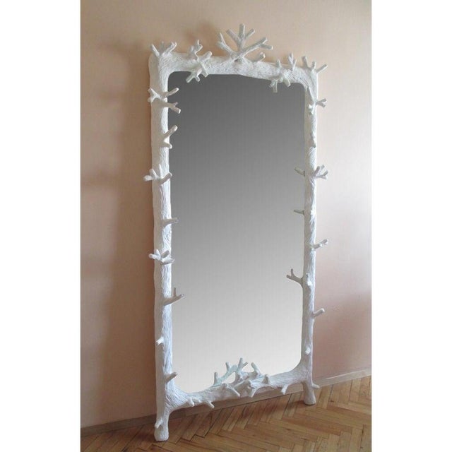 A sculptural oversized floor mirror attributed to John Dickinson, distinguished by its striking organic frame inspired by...