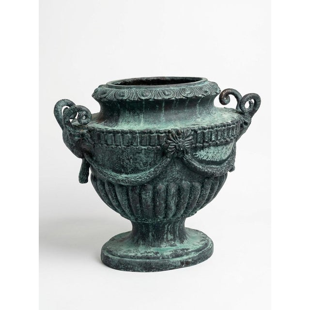 Elegantly detailed and commanding in presence, this Neoclassical style cast iron urn brings timeless European...