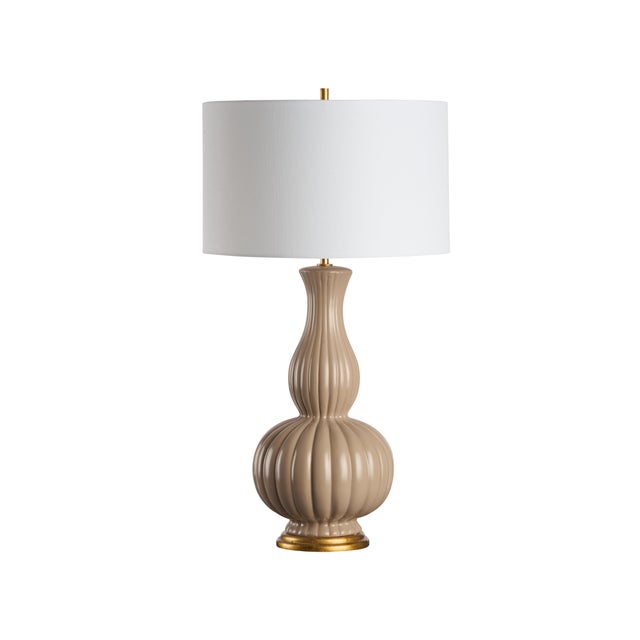 The timeless ceramic shape with soft sand-colored finish and white shade of the Augusta Lamp creates understated luxury...