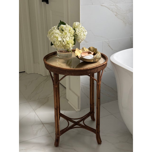 Handcrafted vintage rattan and bamboo side table featuring a round woven grasscloth top set beneath protective glass and...