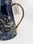 A striking Morris & Co. “Strawberry Thief” porcelain pitcher, finished in a rich navy ground with elegant gold-toned...