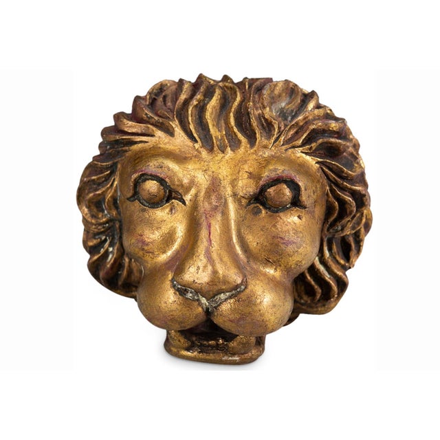Striking pair of vintage gilt lion head sculptures featuring fully dimensional carving and richly antiqued gold finish....