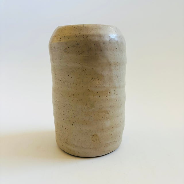 A vintage studio pottery vase. Nice organic cylinder shape. Finished in a pale gray speckled glaze. Signed "Bravo" on the...