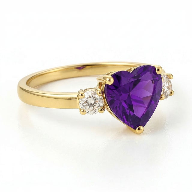 Amethyst Heart Three-Stone Ring This elegant ring showcases the captivating beauty of an amethyst gemstone, designed in a...