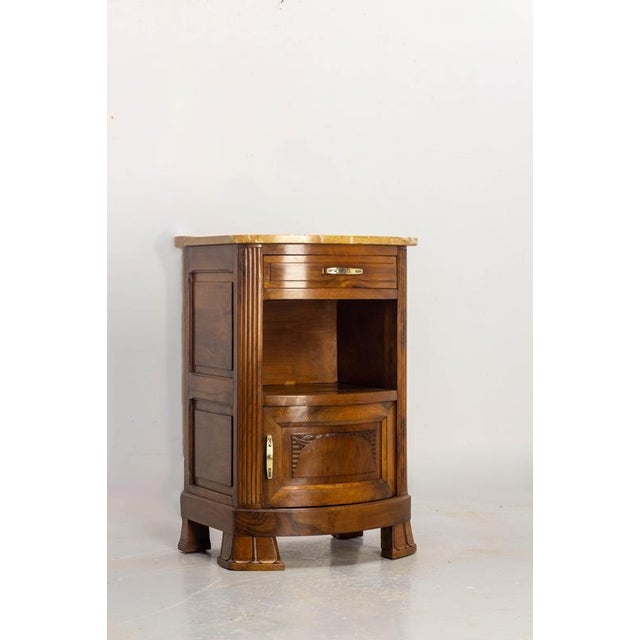 An elegant French Art Deco-era nightstand, crafted circa 1920 from walnut and walnut veneer. Its slightly curved front is...