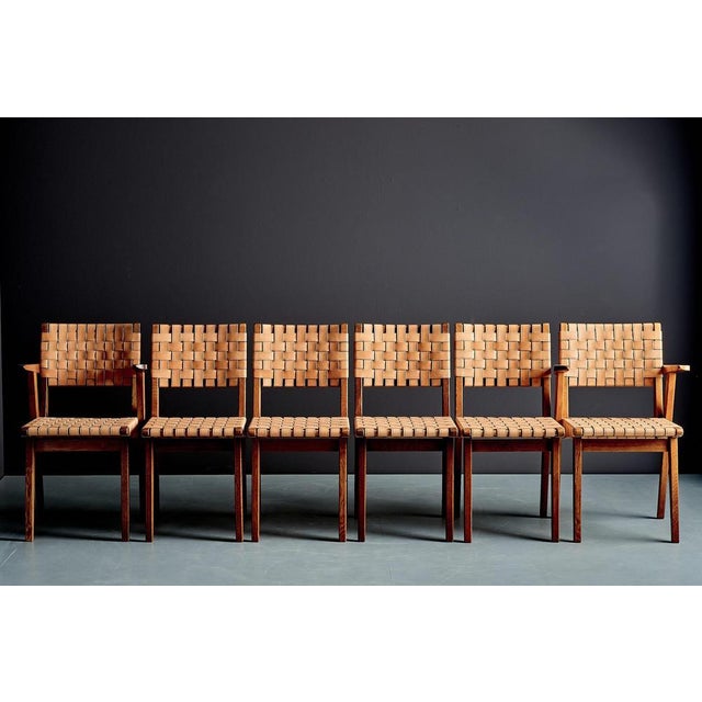 A rare set of ten French dining chairs from the 1950s, composed of eight side and two armchairs. The solid wooden frames...