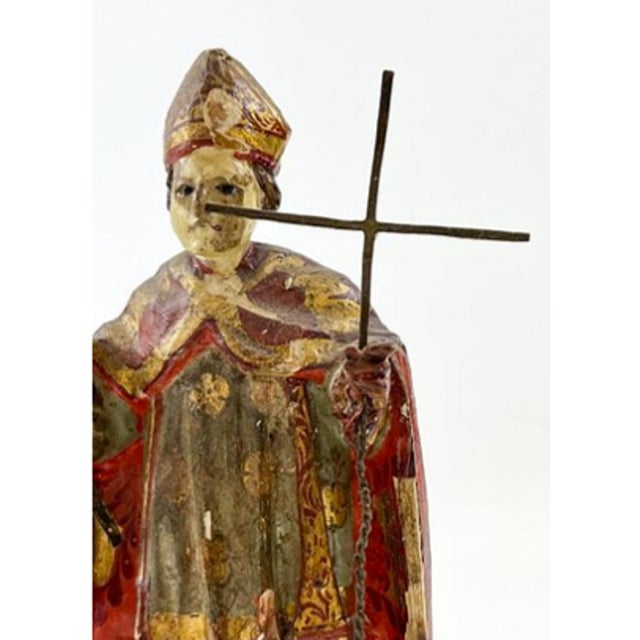 A remarkable antique Spanish Colonial devotional bulto depicting a bishop saint, hand-carved in wood and richly decorated...