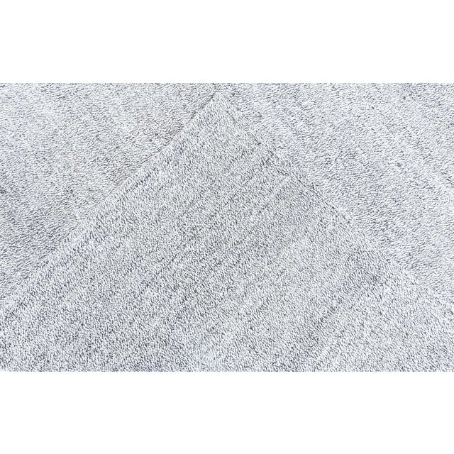 This Modern Kilim Rug embodies simplicity, texture, and timeless versatility. Measuring 8' x 7', it is meticulously...