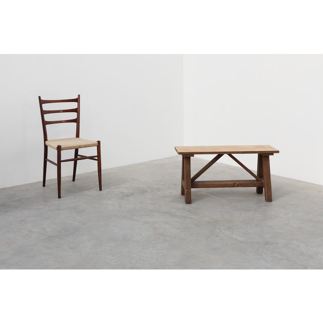 A solid oak trestle bench from France, dating to around 1900. This piece exemplifies the straightforward utility and...