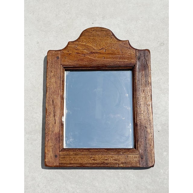 A charming solid wood wall mirror featuring a simple, traditional silhouette enhanced by a gently arched top. Its warm...