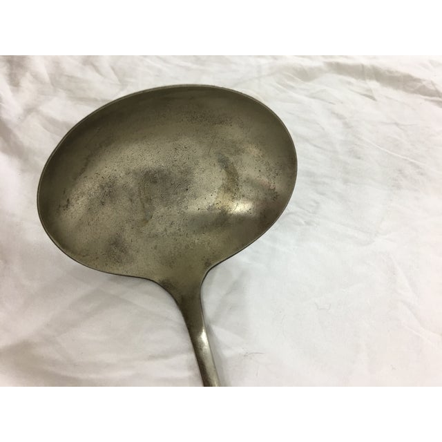 This ladle dating from the 1960's and is labeled "MED DEPT USA". In good condition, with tarnish consistent with age.
