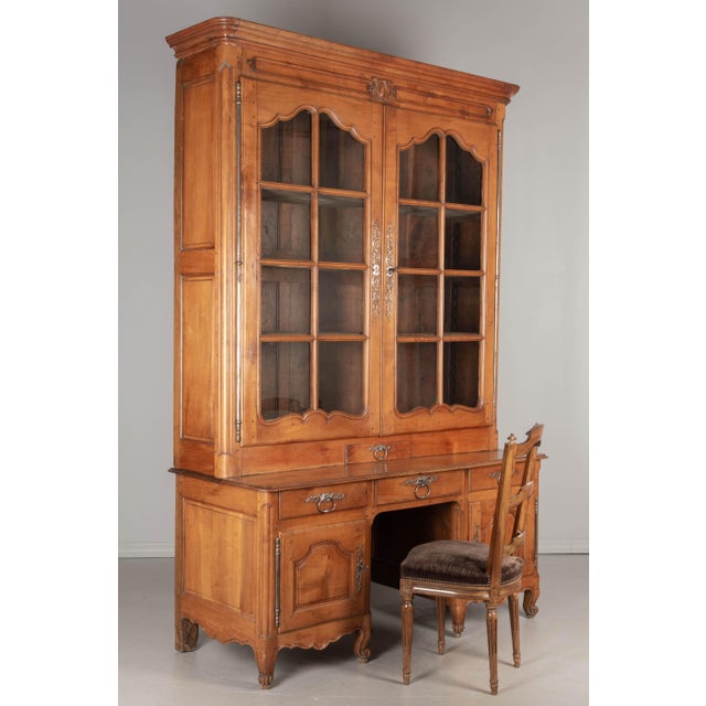 A grand scale 18th century French Louis XV Period bibliothèque, or bookcase, from the Loire Valley. Made of solid cherry...