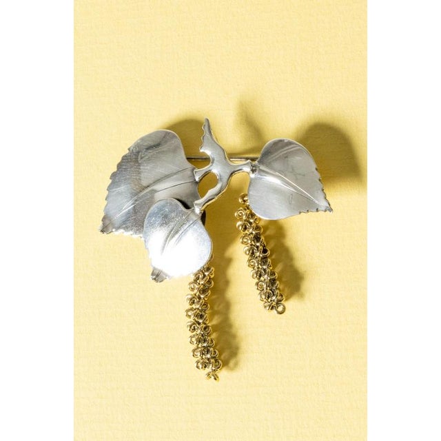 Stunning silver brooch by Gertrud Engel, in the form of birch leaves, with two gilded seed pods loosely suspended....