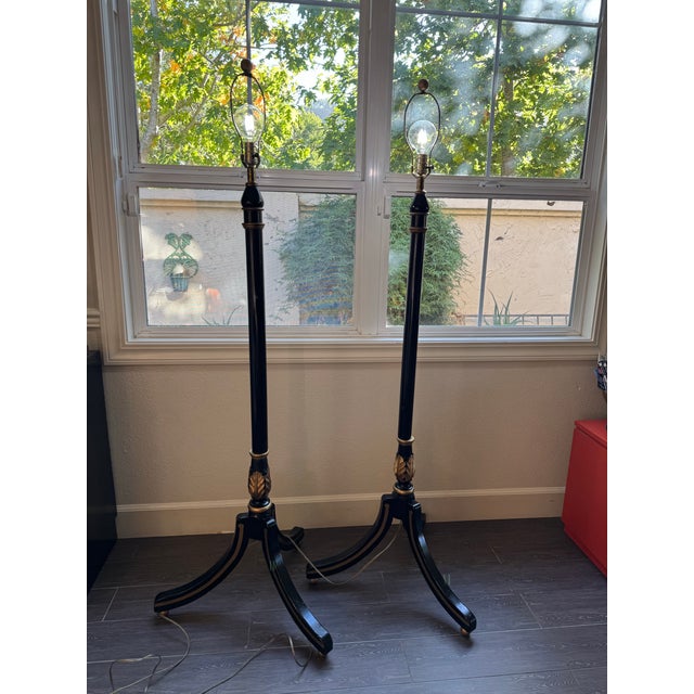 Timeless Empire-revival style. This pair showcases tapered black columns highlighted by gold accents, distinctive leaf-...