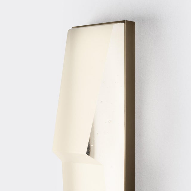 Modern with a jewel-like form, the Prism Sconce is composed of a faceted cast glass diffuser set within a brass frame and...