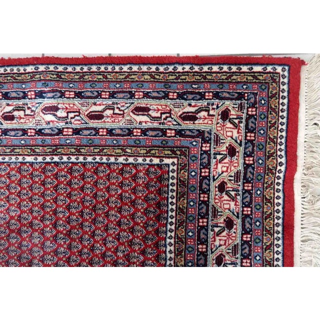 Handmade vintage Indian Seraband rug in repeating pattern and red shade. The rug is from the end of 20th century in...