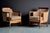 A refined pair of Art Deco lounge chairs with sculptural wooden frames and gently curved backs. The design combines strong...