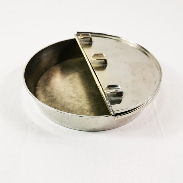 This ashtray originated in Germany in the 1960s. It features a simple, functional design. Made of nickel-plated brass...
