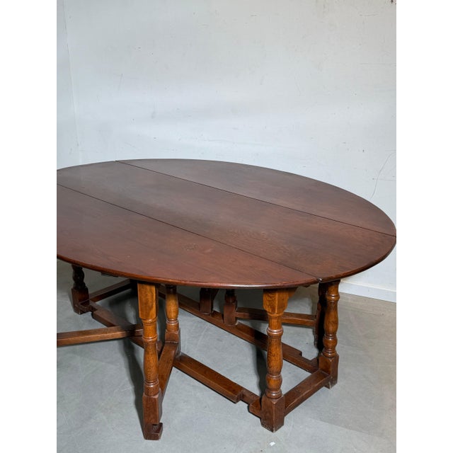 Beautiful antique gateleg dining table crafted in solid oak, featuring a classic drop-leaf design with elegant turned legs...