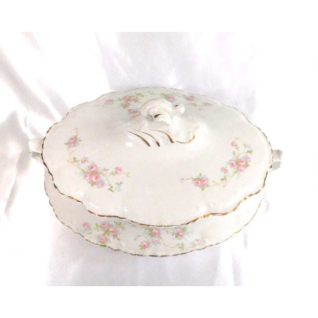 This is a Homer Laughlin covered casserole dish in white with pink flowers and gold trim. The bottom of the casserole dish...